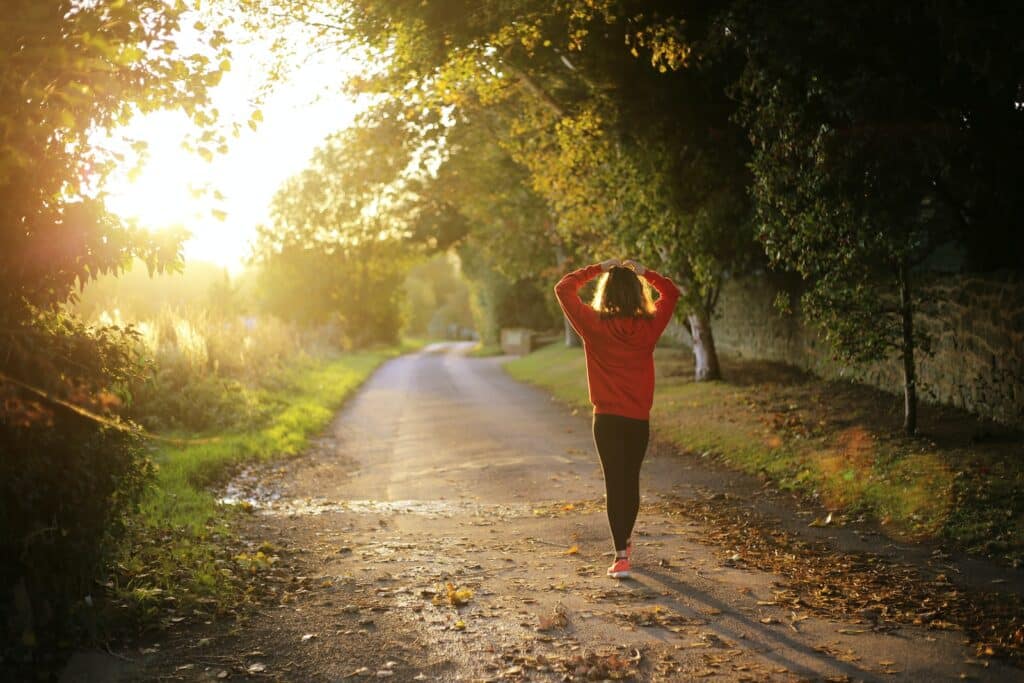 woman walking on pathway during daytime - angrylionfitness.com