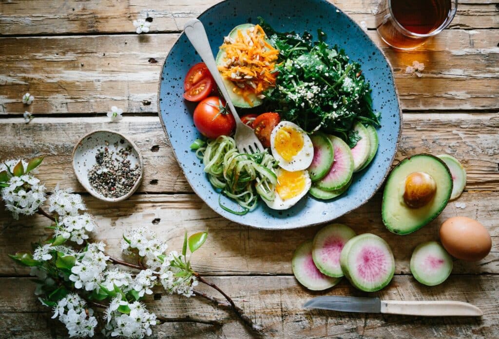 poached egg with vegetables and tomatoes on blue plate keto