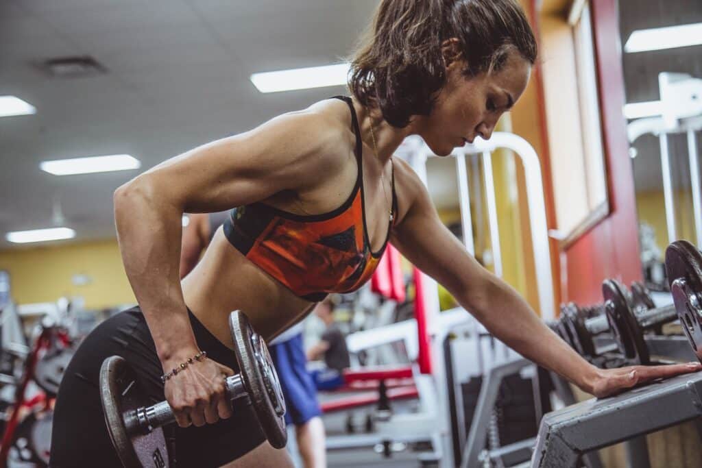 woman seriously performing gym exercise STRENGTH TRAINING