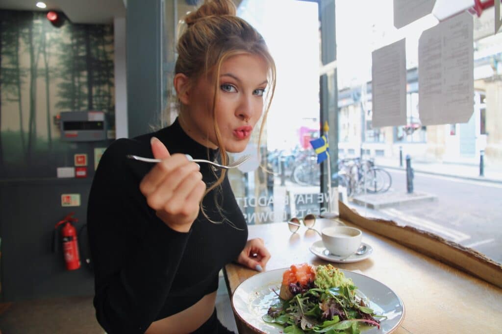 woman in black long sleeve shirt eating - Low-Carb Diet