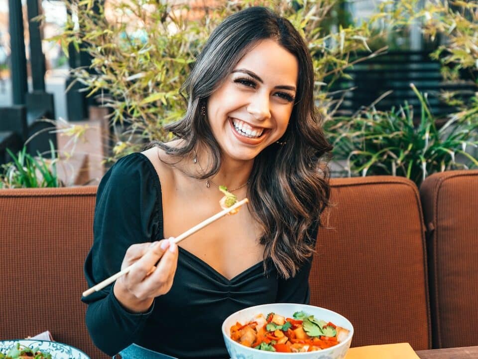 woman in blue long sleeve shirt holding chopsticks women eating