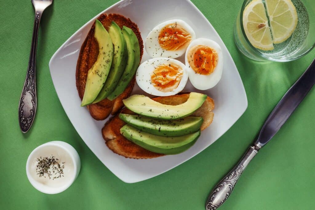 a white plate topped with eggs and avocado Healthy Fats