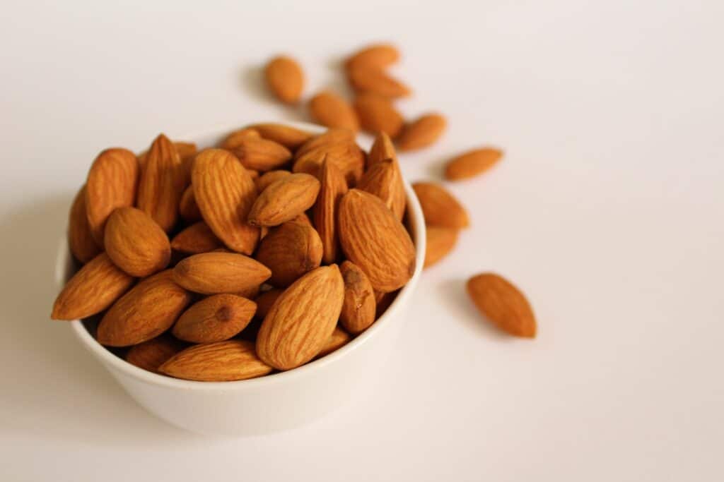 Almonds brown almond nuts on white ceramic bowl