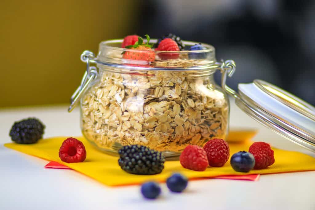 Oats clear glass jar with black berries