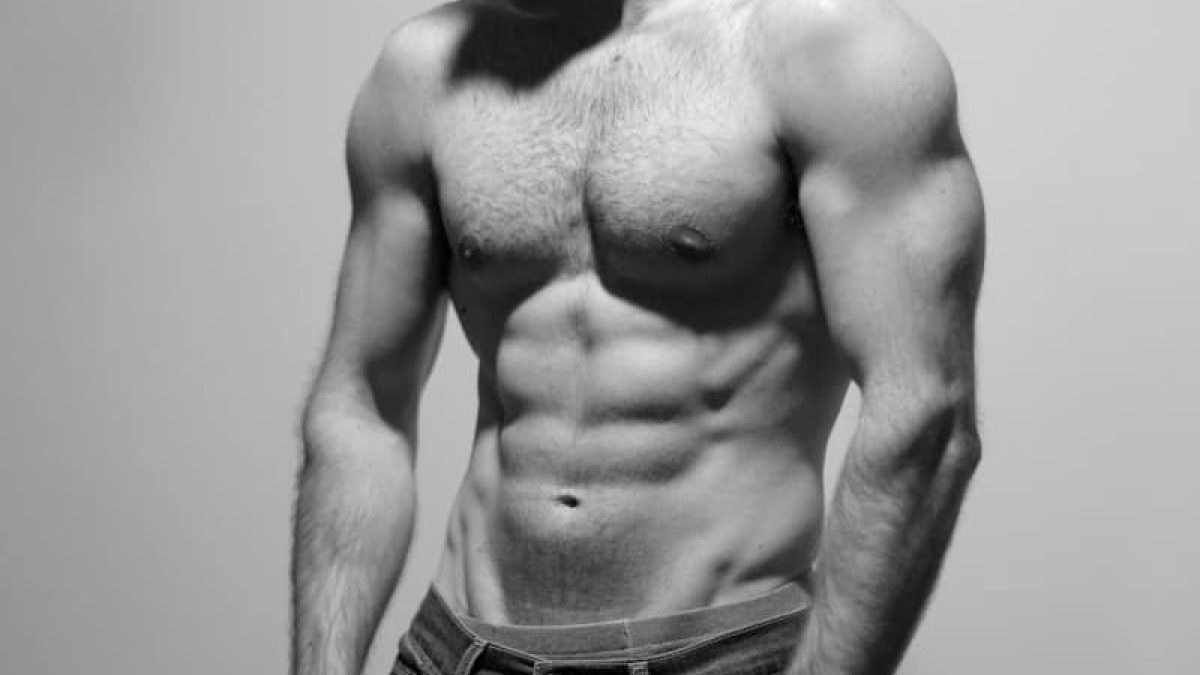 a man with a beard and no shirt posing for a picture